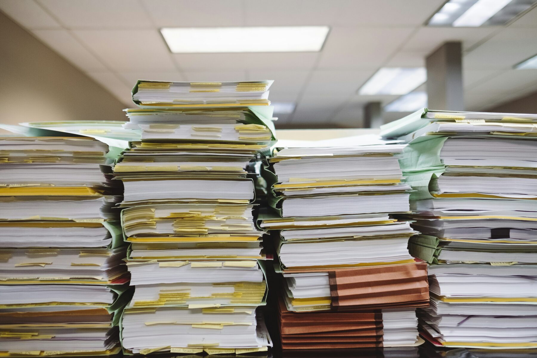 piles of documents stalked on top of each other in an office environment