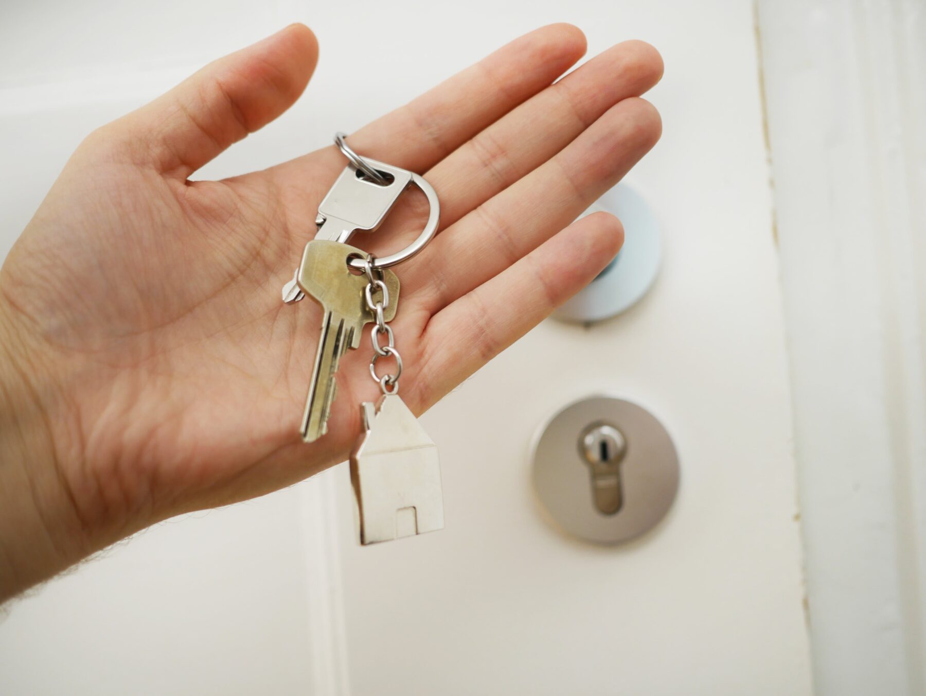 a palm of hand holding key chain, hoa closing documents