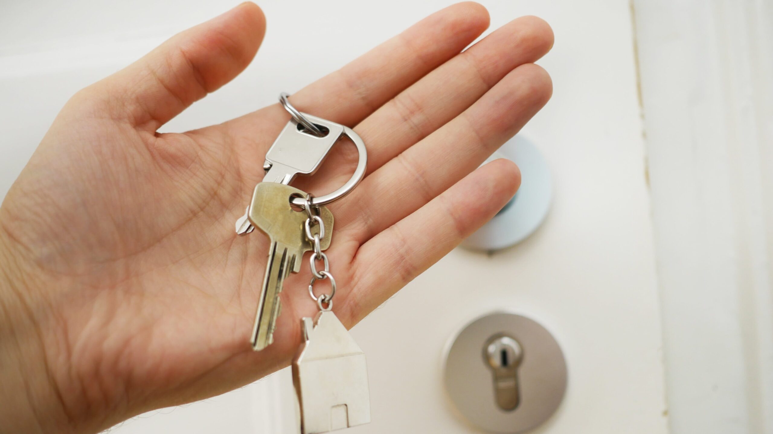 a palm of hand holding key chain, hoa closing documents