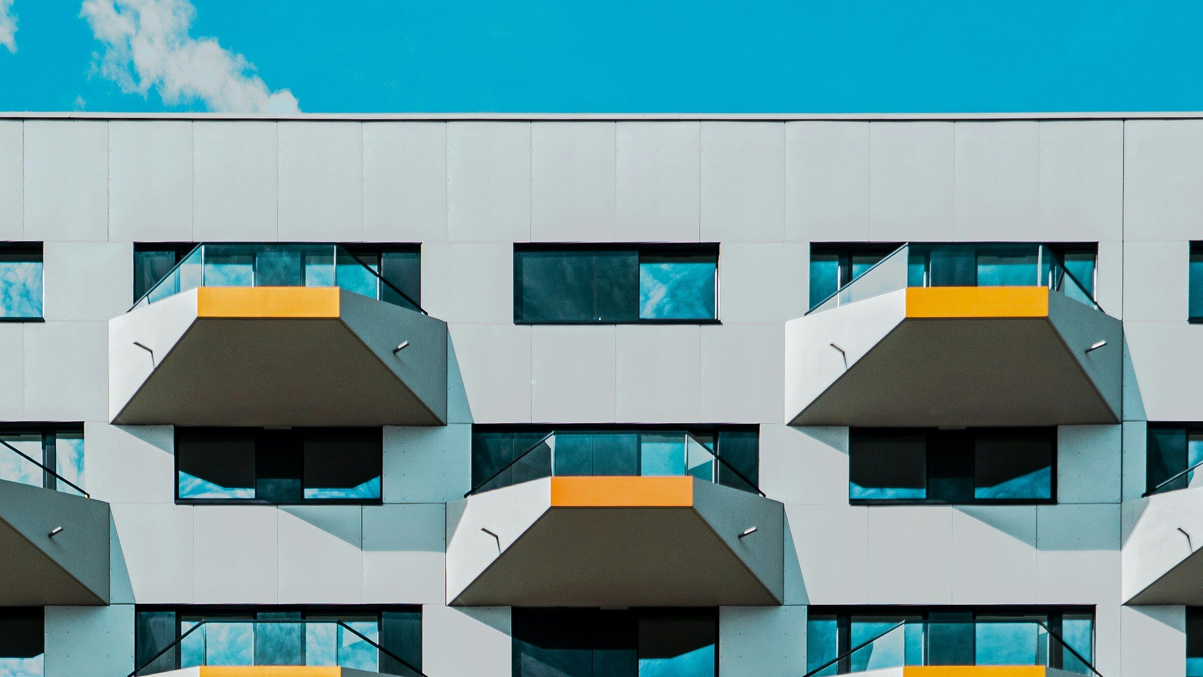 sfr property management abstract gray condo building with yellow accent terraces geometrical on blue sky